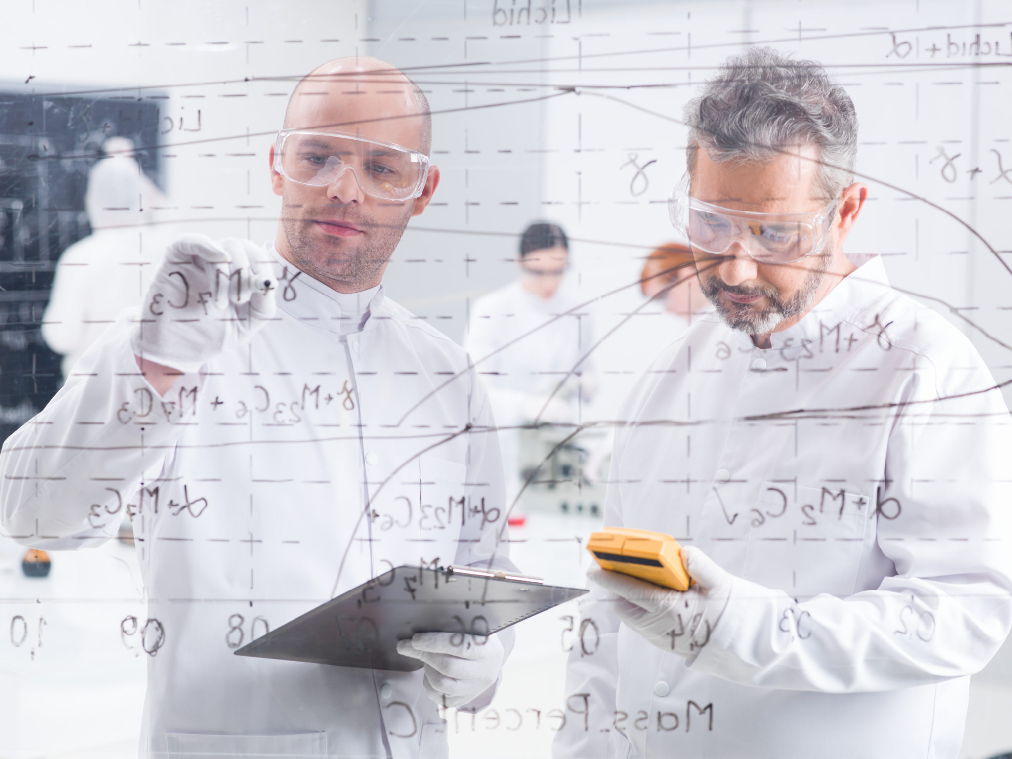 Close-up,Of,Two,Researchers,In,A,Lab,Writing,Formulas,On